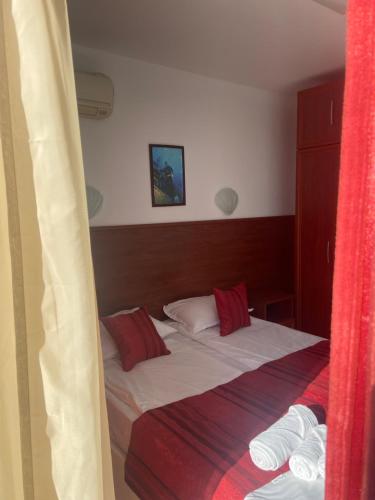 a small bed in a room with a red curtain at Ribarska Sreshta Family Hotel in Tsarevo