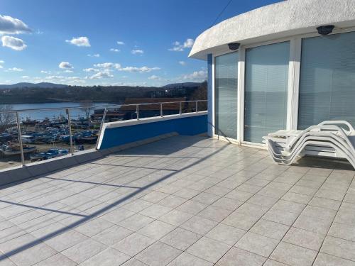a balcony with two white chairs on a house at Ribarska Sreshta Family Hotel in Tsarevo