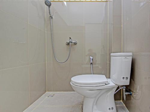 a bathroom with a toilet and a shower at Super OYO 92101 Elma Guesthouse in Yogyakarta