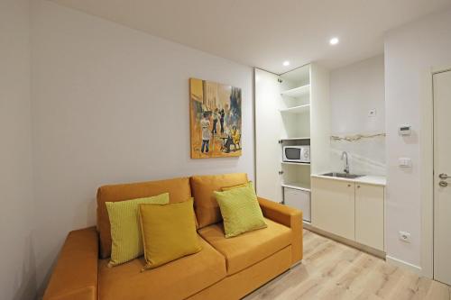 a living room with a couch and a kitchen at FLH Porto Downtown GuestHouse in Porto