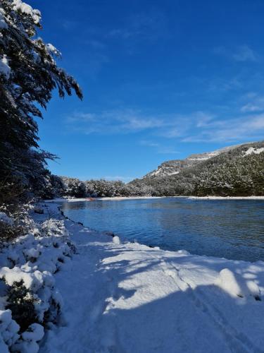a river covered in snow next to a mountain at Green Baker Lodge in Puerto Bertrand