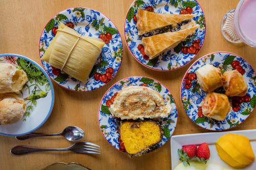 a table topped with plates of food and desserts at Carícia do Vento Pousada Boutique in Monte Verde