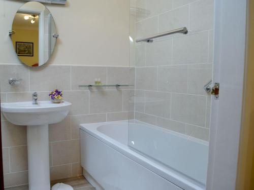 a bathroom with a bath tub and a sink at Anvil in Dalbeattie