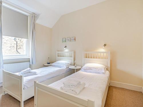 2 camas individuais num quarto com uma janela em Tidal Watch - Uk37851 em Alnmouth