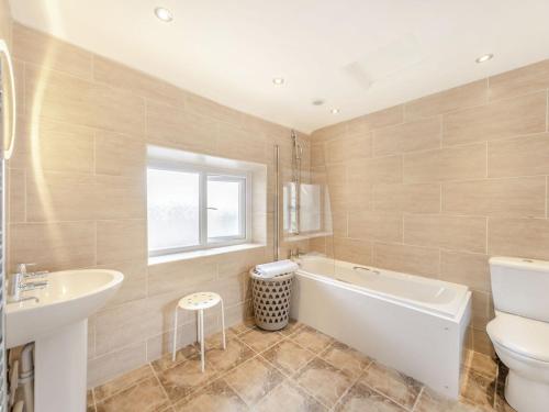 uma casa de banho com uma banheira, um lavatório e um WC. em Tidal Watch - Uk37851 em Alnmouth