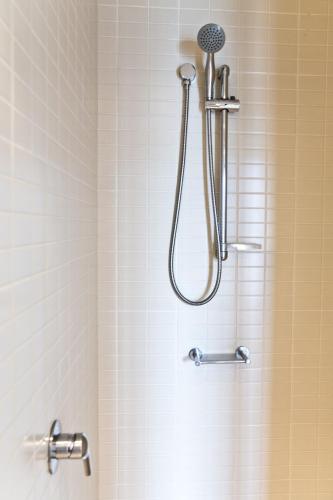 a shower with a shower head in a bathroom at Cairns Private Apartments in Cairns
