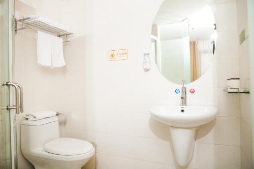 uma casa de banho com um WC, um lavatório e um espelho. em Shenzhen Green Oasis Hotel, Baoan em Bao'an