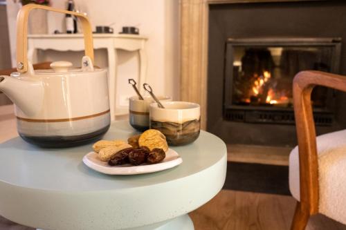 a table with a plate of food and a fireplace at Langhe Country House in Neive