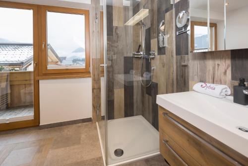 a bathroom with a shower and a white sink at Haus Sylvia in Reith im Alpbachtal