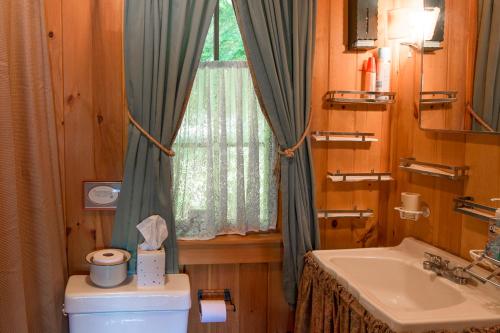 a bathroom with a toilet and a sink and a window at FRE-Wil in Lincolnville