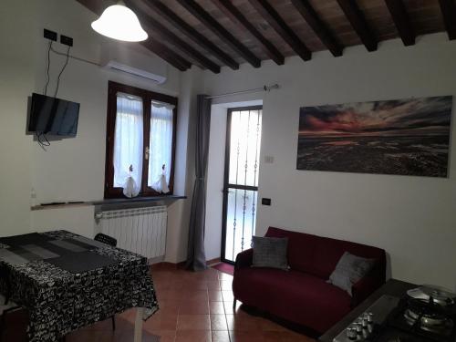 - un salon avec un canapé et une table dans l'établissement La casa in giardino, à Volterra