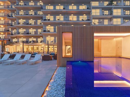 a swimming pool with a hotel in the background at Hotel Saratoga in Palma de Mallorca