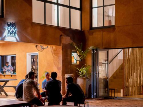 a group of people sitting outside of a building at Tabokana House in Victoria Falls