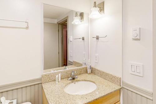 y baño con lavabo y espejo. en Kingswood 2C Condominium, en Quechee