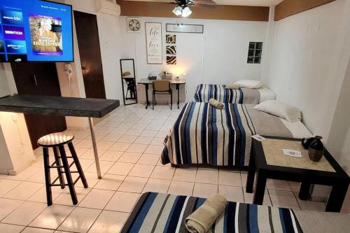 a room with two beds and a flat screen tv at Habitacion tipo hotel centrico 3 camas, cocina,WIFI E in Ciudad Valles