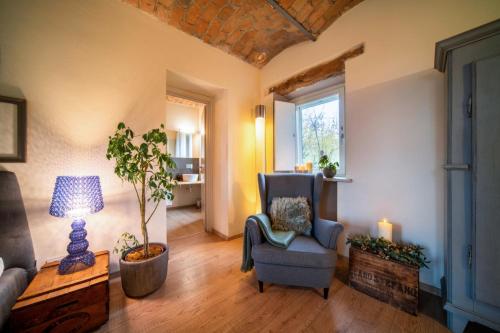 a living room with a chair and a lamp at Langhe Country House in Neive