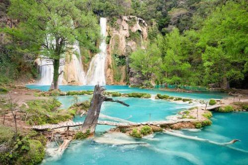 una cascada en medio de un río con agua azul en Habitacion tipo hotel centrico 3 camas, cocina,WIFI E, en Ciudad Valles