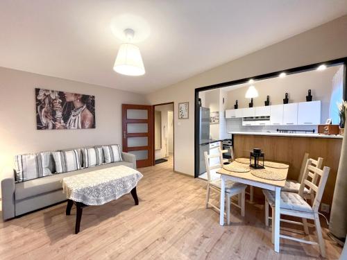 Una sala de estar con un sofá y una mesa y una cocina. en 14 Gdynia Centrum - Apartament Mieszkanie dla 4 os, en Gdynia