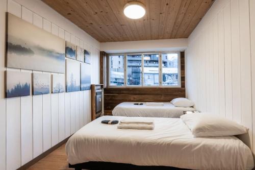two beds in a room with two windows at Appartement Europa in Briançon