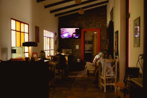 a living room with people sitting in chairs and a tv at Portón Rojo in Liebig