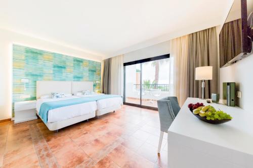 アルカイデサにあるAldiana Club Costa del Solのベッドルーム1室(ベッド1台、テーブル、フルーツボウル付)