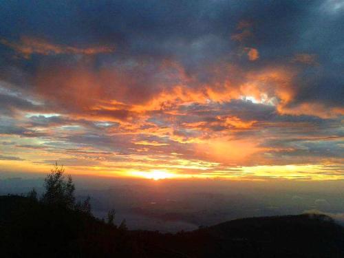 a sunset in the sky with the sun in the horizon at Bel View Guest House in Haputale