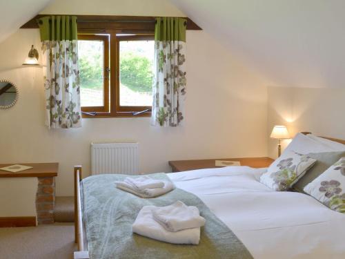 een slaapkamer met een bed met twee handdoeken erop bij Applebarrel Barn in Dunkeswell