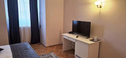 a living room with a tv on a table with a tv at Hotel Triumf in Bucharest