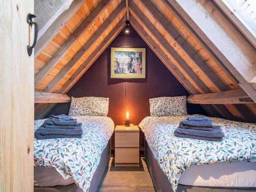 two beds in a attic room with wooden ceilings at Russet-uk41836 in Clevedon