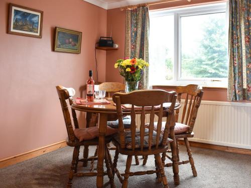 ein Esszimmer mit einem Tisch, Stühlen und einem Fenster in der Unterkunft Sparrows Nest in Preston