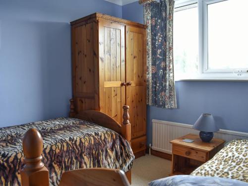 Schlafzimmer mit einem Bett und einem Holzschrank in der Unterkunft Sparrows Nest in Preston