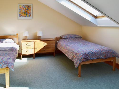 a attic bedroom with two beds and a skylight at Fenham Barn in Soulby