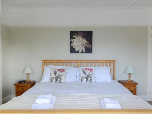 a bedroom with a large bed with two pillows at Riverside House in Beccles