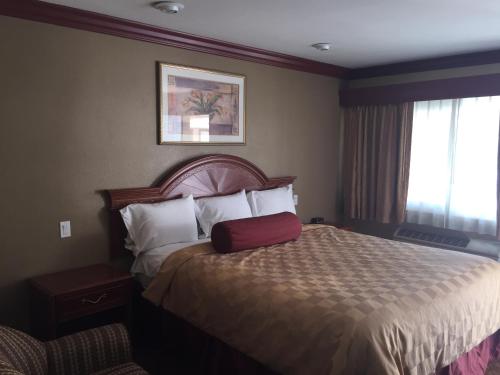 a hotel room with a bed with a red suitcase on it at Thunderbird Lodge in Riverside