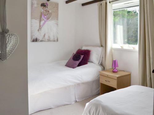 a bedroom with two beds and a picture of a woman at Walnut in Thornbury