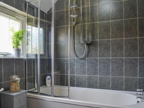 a bathroom with a shower and a bath tub at Chapel Farm Cottage in Wetwang