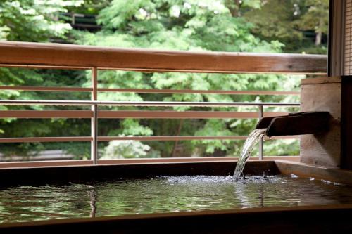 a water fountain in front of a wooden fence at Zazan minakami in Minakami
