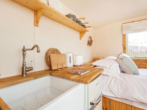 una cocina con fregadero y una cama en una habitación en Woodside Hut 1 - Uk36105, en Auchterneed
