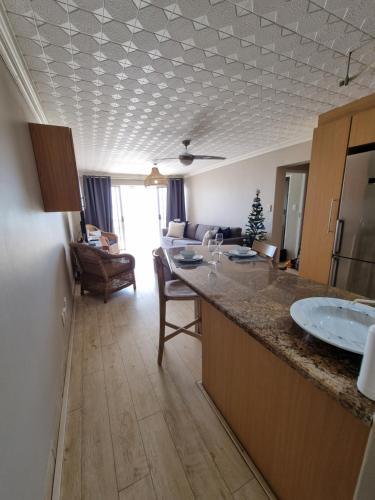 a kitchen with two sinks and a living room at Diaz Views 10 in Jeffreys Bay
