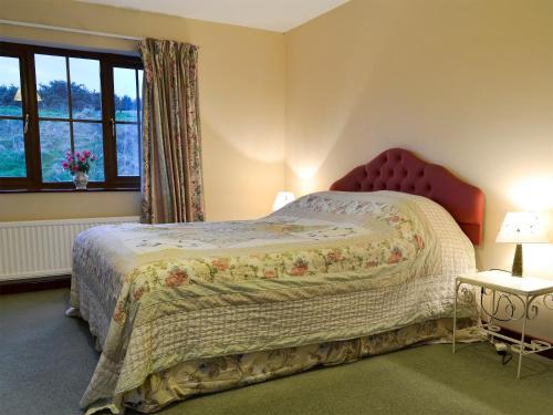 Schlafzimmer mit einem Bett und einem Fenster in der Unterkunft Cleiriach in Gwytherin