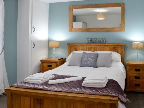 a bedroom with a bed with towels and a mirror at Key To The Esk in Longtown