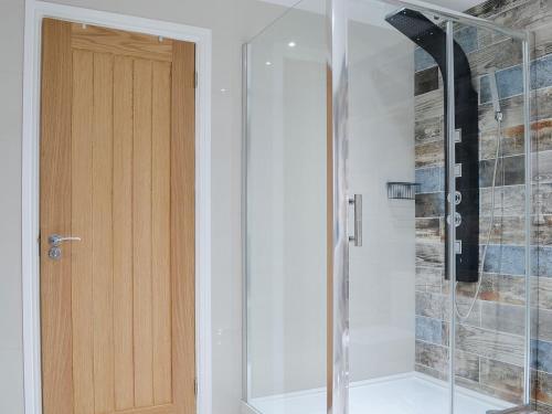 a shower with a glass door in a bathroom at Key To The Esk in Longtown