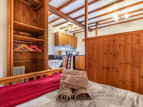 Stanton in PeakにあるBoskin Cottageの木製の壁のベッドルーム1室(ベッド1台付)