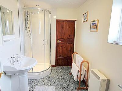a bathroom with a sink and a shower and a toilet at Beach Cottage in Winterton-on-Sea