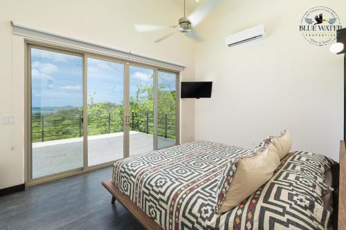 - une chambre avec un lit et une grande fenêtre dans l'établissement Miramar #28 -A Brand new Modern 4 BR Ocean View home at Mar Vista, à Brasilito