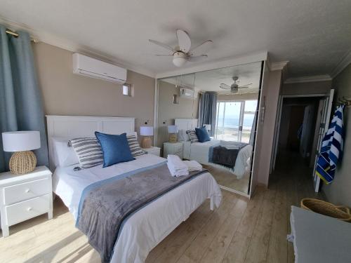 a bedroom with two beds and a large mirror at Diaz Views 10 in Jeffreys Bay