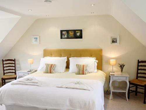 1 dormitorio con 1 cama blanca grande y 2 sillas en The Owl House en Bishops Waltham