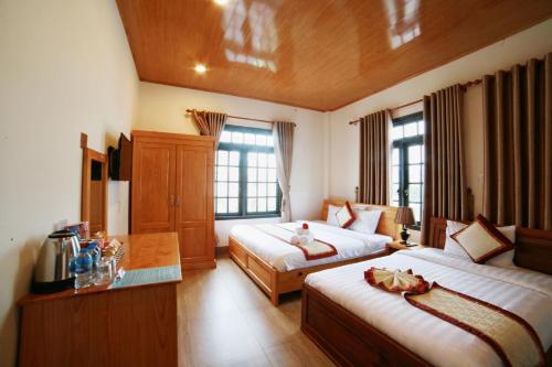 a hotel room with two beds and two windows at KB VILLA in Da Lat