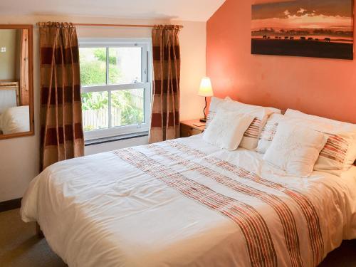 1 dormitorio con 1 cama grande y ventana en Willow Cottage, en Newlyn East