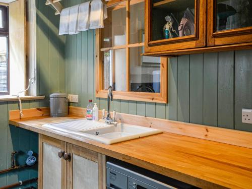 a kitchen with a sink and a wooden counter top at Rosebank Cottage in Borgue